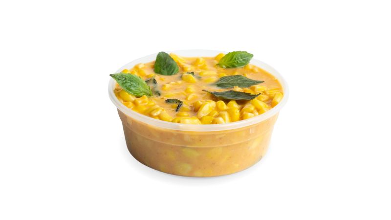A cup of corn simmered with aromatics, roasted garlic, red curry paste, and Thai basil